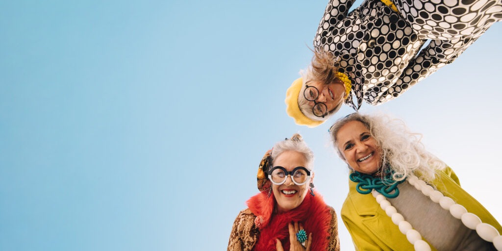 3 older women looking down at a camera on the ground