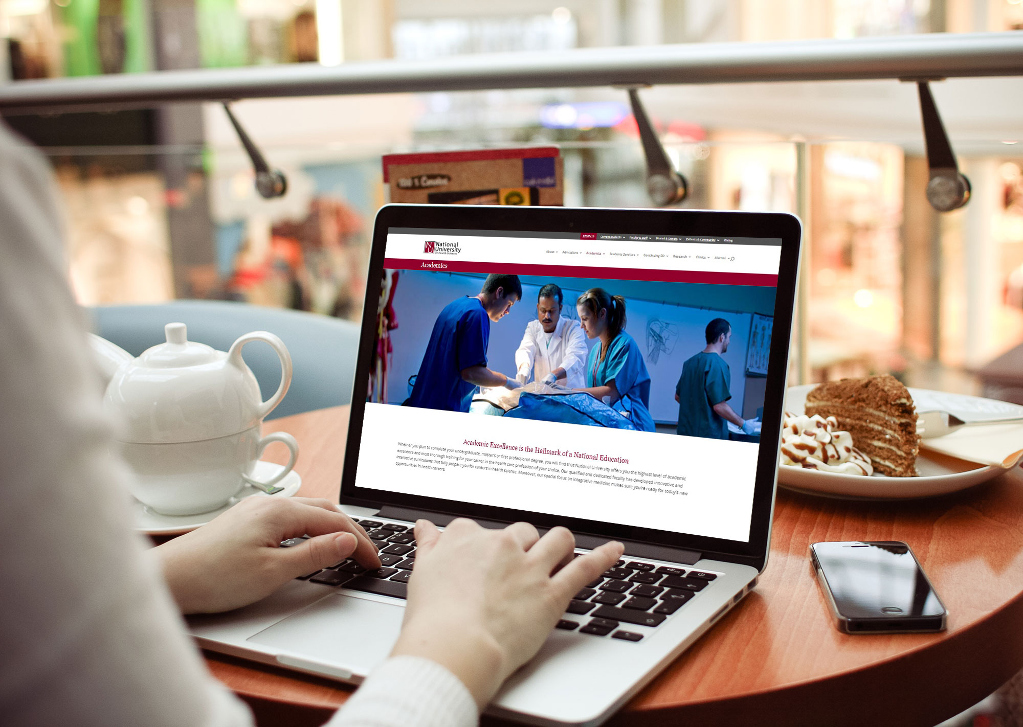 student look at an accessible university website on a laptop in a cafe.