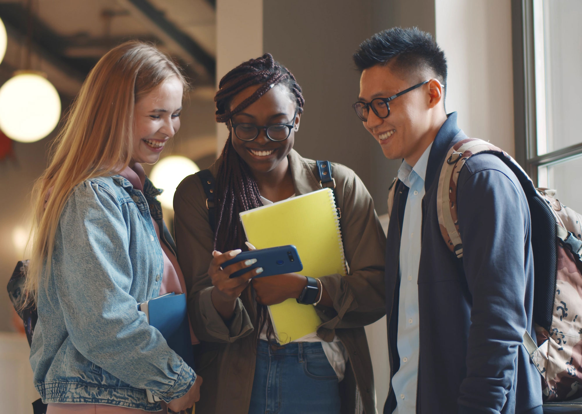 3 students looking at university website on a phone