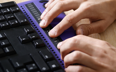 visually impaired person using braille keyboard