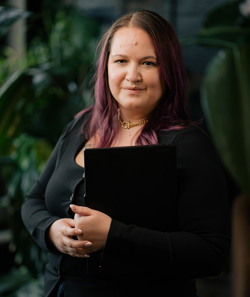 Marisa VanSkiver looking at camera and holding laptop
