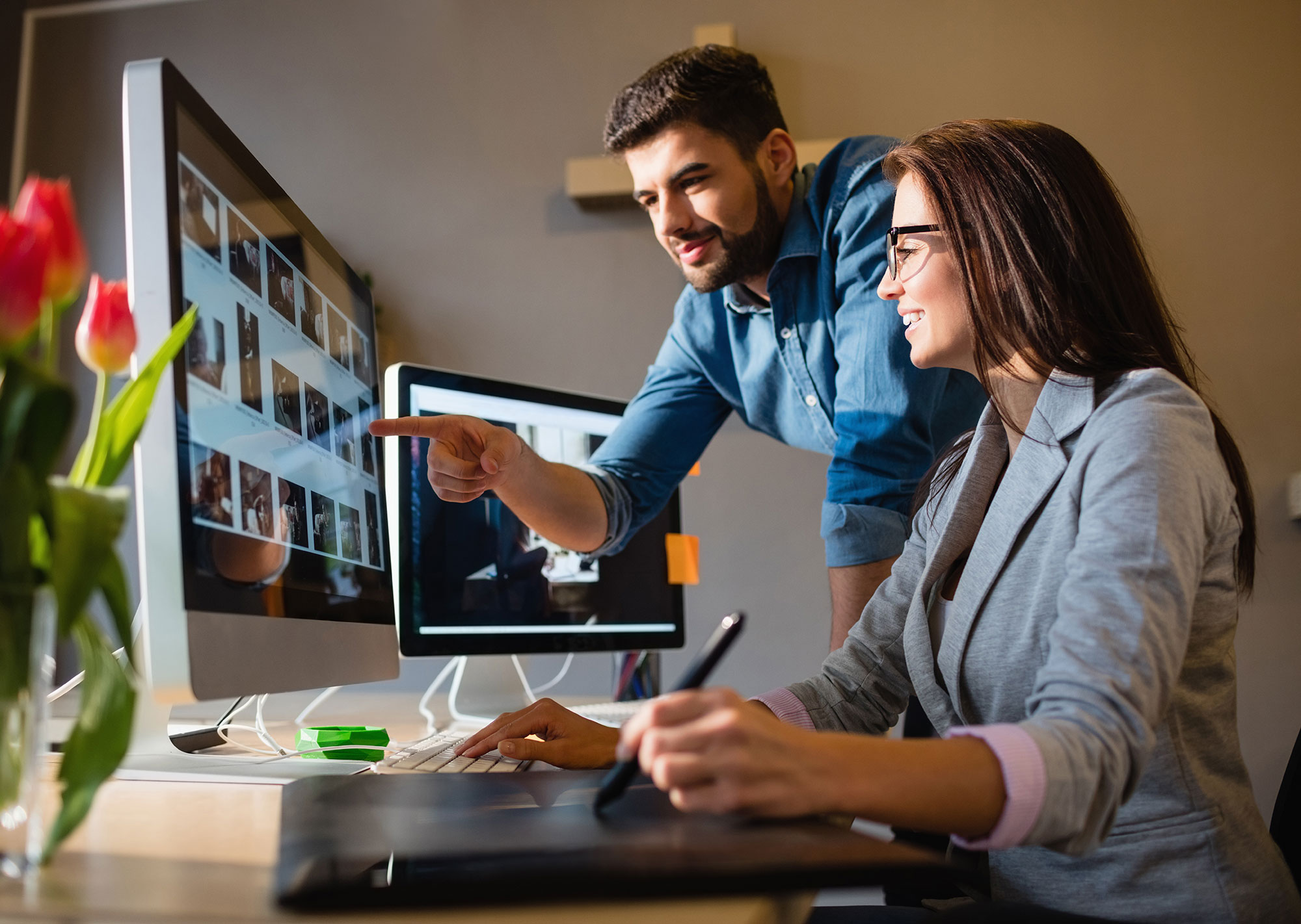 Two people looking at canva graphics on a computer screen