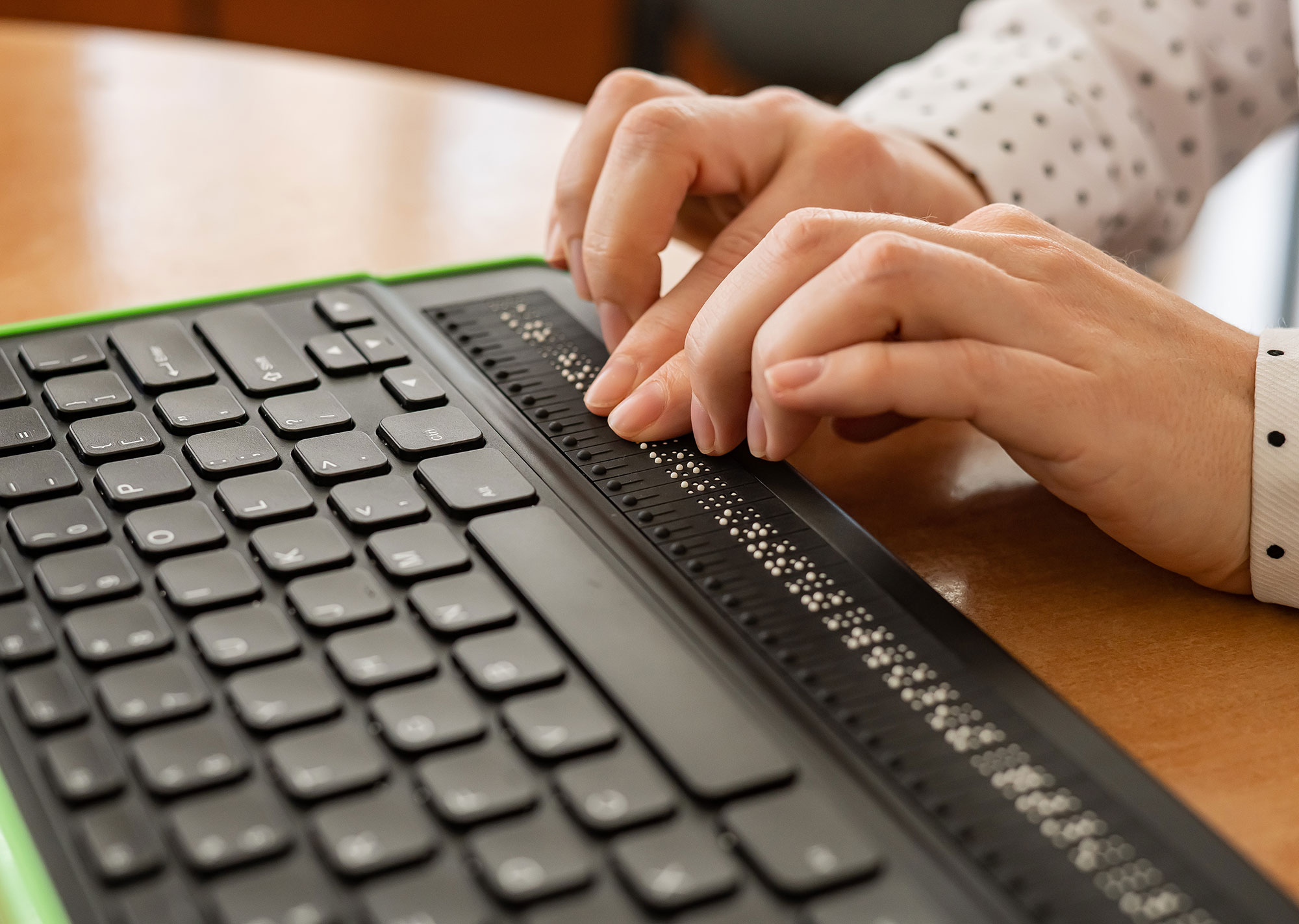 blind woman uses a braille keyboard to navigate the internet