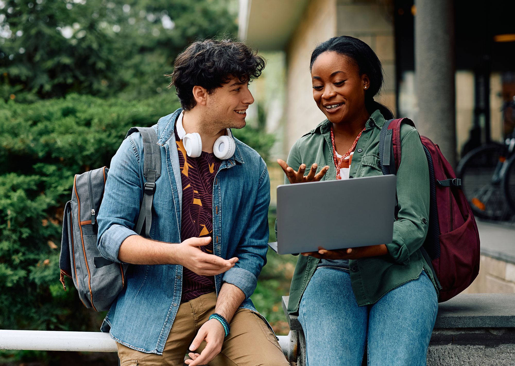two students outside looking at a college website
