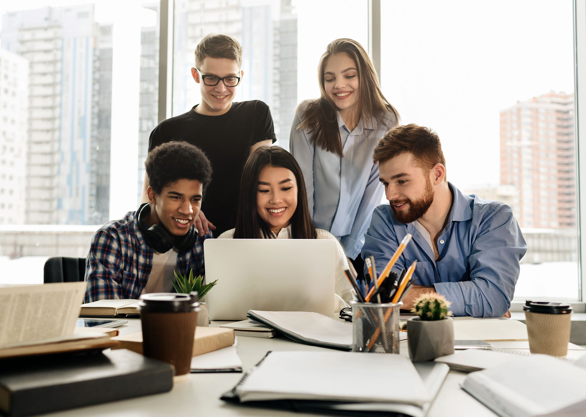 diverse group of people looking at website together on one computer